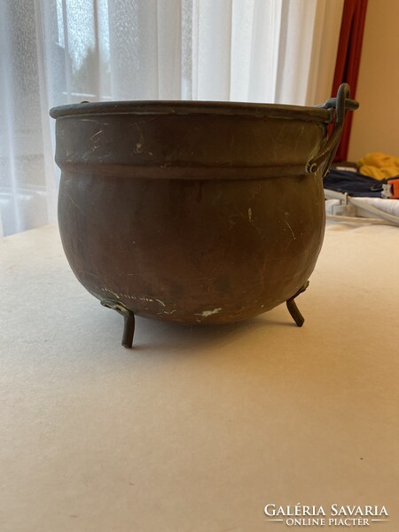 Antique three-legged copper cauldron .